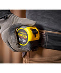 Worker holstering Fatmax Tape Measure With Blade Armor And Dual Scale 8m Length, Mylar Coated Blade Delivers 10x Abrasion Resistance