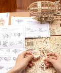 Hands assembling 3D Wooden Puzzle Airship Kit For Adults And Teens Educational Brain Teaser Model with plywood pieces and instructions.
