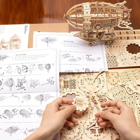 Hands assembling 3D Wooden Puzzle Airship Kit For Adults And Teens Educational Brain Teaser Model with plywood pieces and instructions.