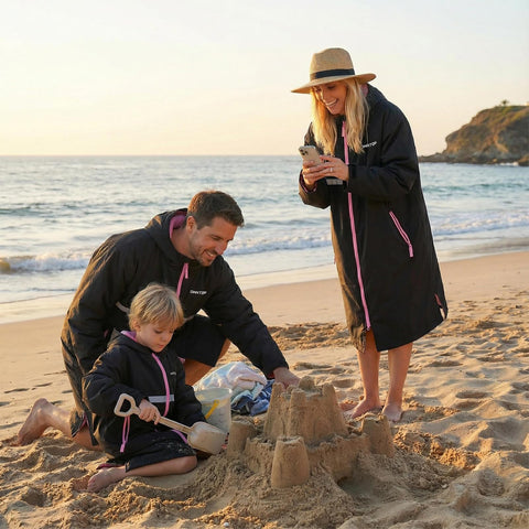 Family wearing Mens Waterproof Swim Parka With Hooded Poncho For Beach Or Pool building sandcastles, showcasing oversized coats