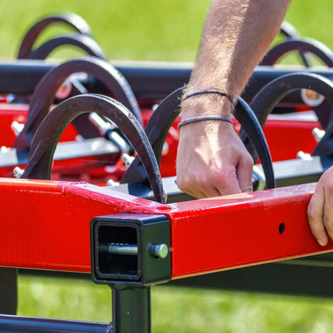 Man installing Heavy Duty 9 Inch Hay Grapple Replacement Hook Pack For Hay Accumulator onto red farm equipment frame