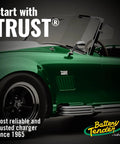 Close-up of a classic green sports car with chrome details, featuring 'Start with TRUST®' branding.
