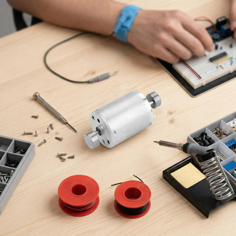 Dual Shaft 12V DC Vibration Motor with high torque, shown on workspace with tools, for DIY vibe devices and prototyping projects.