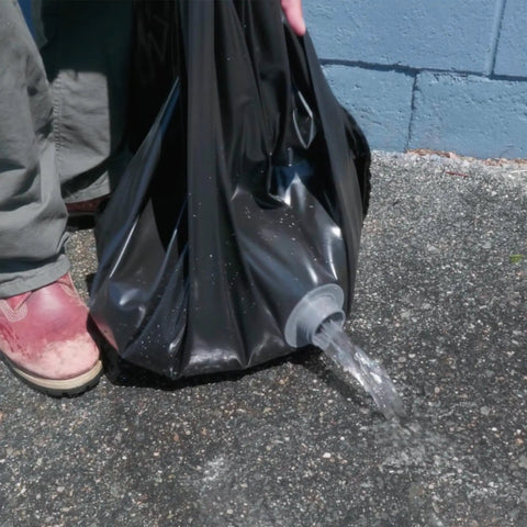 Reusable Water-Filled Flood Barrier Curb for Quick Home Flood Defense showing water draining from heavy-duty PVC material.