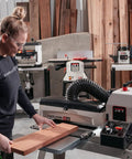 Person using heavy duty infeed and outfeed tables for drum sanders JWDS-1632 1836 in woodworking shop, extending surface to 40 inches