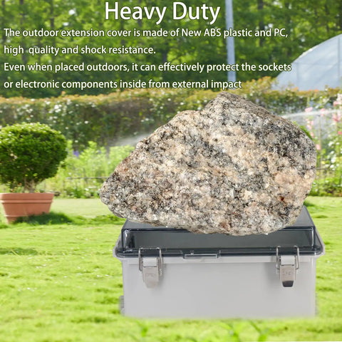Heavy Duty Outdoor Waterproof Electrical Box With Clear Hinged Lid IP55 Tough As Nails Junction Cover For Power Strips Extension Cords And Outlet Protectors Dead Easy Weather Shield 8.9 X 4.9 X 4.3 Inch with rock on lid in garden.