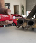 Close-up of a red Permatex Right Stuff gasket maker tube (3 oz) applying to an exhaust manifold gasket