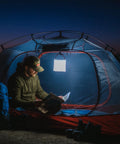 Camper reading in tent illuminated by Your Go To Quick Inflate 2 In 1 Solar Lantern And Phone Charger For Camping Hiking And Travel Rechargeable LED Light