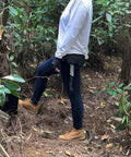 Person outdoors with Beast Mode Full Tang Chopping Axe With Wooden Handle on belt, forest setting