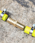 Solid Brass Garden Hose Repair Connector Kit With Half Inch Barb Fittings Dual Head Hose Repair Couplers Includes Stainless Steel Clamps Reusable 2 Pack For Lawn And Yard Watering Easy DIY Fix shown connecting yellow hoses on concrete surface