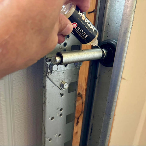 Applying All-In-One 5oz Synthetic Ester Lubricant Spray With Precision Needle for Door Hinges on a garage door hinge