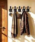Top Shelf Matte Black Wall Coat Hooks Four Pack holding keys, scarf, and leather jacket on a wall, heavy duty for entryway.