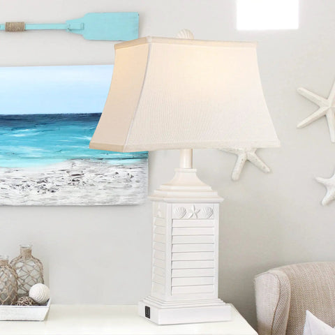 Coastal White Resin Table Lamp with USB A to C Outlet in living room setting, featuring seashell details and beige lampshade.