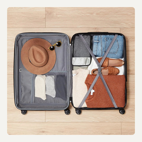 Amazon Basics 30-inch hardside luggage, open view showing clothing; black shell, grey interior