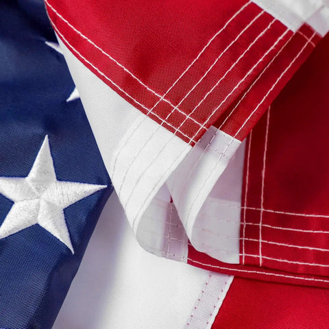 Close-up of Heavy Duty 5x8 Ft US Flag With Embroidered Stars And Sewn Stripes, Nylon Construction, Brass Grommets, UV Protected For Outdoors