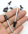 Two Straight Up Solid Aluminum Fuel Door Rivets For Toyota Gas Cap Hatch Snap Fasteners held in hand, showcasing black stems.