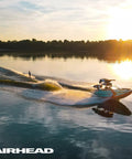 Person water skiing at sunrise using 75 Foot Water Ski Rope With Tractor Grip Handle 1 Section Aluminum Core 12 Inch Grip Blue And White