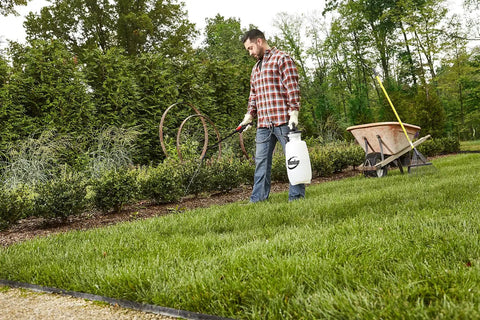 Man using 2 Gallon Lawn And Garden Sprayer For Controlling Insects And Weeds Or Cleaning Decks And Siding with comfort grip outdoors.