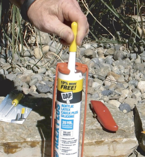 Person using Reusable Caulk Tube Cap With Built In Puncture Pin 2 Pack Keep Caulk Fresh Between Jobs outdoors.