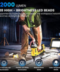 Ultra Bright 12000 Lumen LED Work Light With 128 LEDs Portable Flood Light illuminating a construction site, worker using power tool.