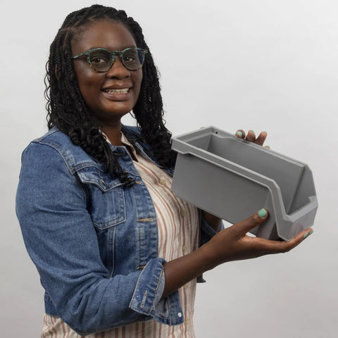 Person holding medium plastic storage bin, stackable clear organizer container with open front design for easy access