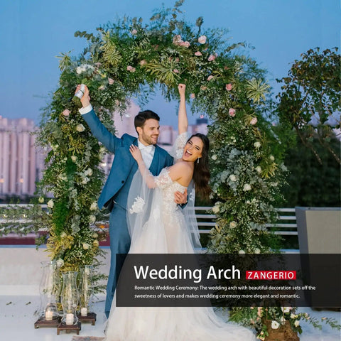 Couple posing under a wedding arch at sunset, decorated with climbing plants, emphasizing outdoor ceremony decor.