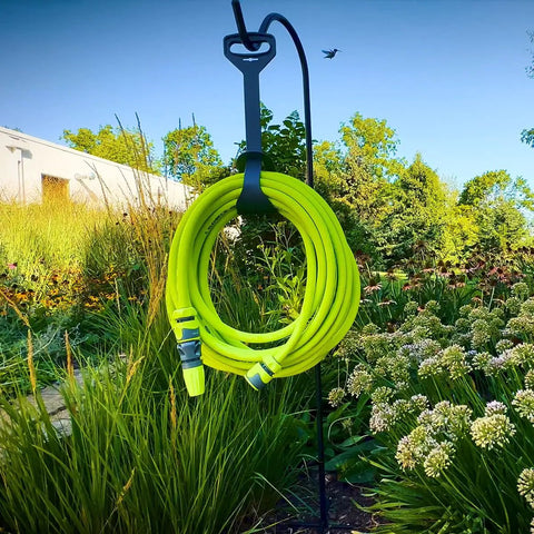 Garden Hose Kit With Quick Connect Attachments Lightweight Flexible Half Inch By Fifty Foot Hybrid Polymer Hose That Coils Easily Includes Twist Nozzle Flow Stop Coupler Spigot Adapter Hose Adapters And Hose Hanger Will Not Kink Under Pressure, hanging in garden.