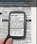 Big Ol Jumbo Size Magnifying Glass With Wide Horizontal Lens 3X Magnification shows newspaper text under lens.
