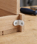 Stainless Steel Right Angle Corner Brackets 24 Pack With Screws White Finish for wood shelves, attached to wooden panels.