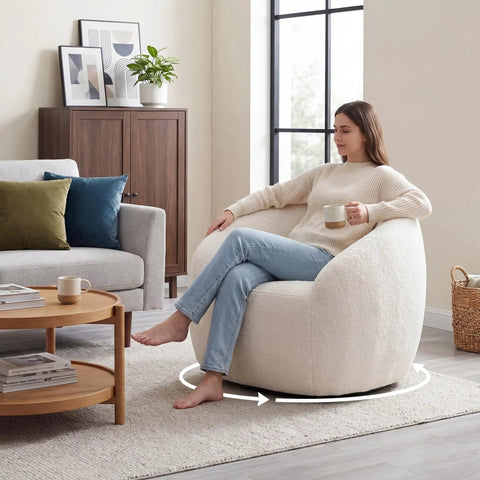 Woman relaxing on White Boucle Swivel Chair With 360 Degree Base, Oversized Round Barrel Accent Chair For Living Room, wide seat visible.