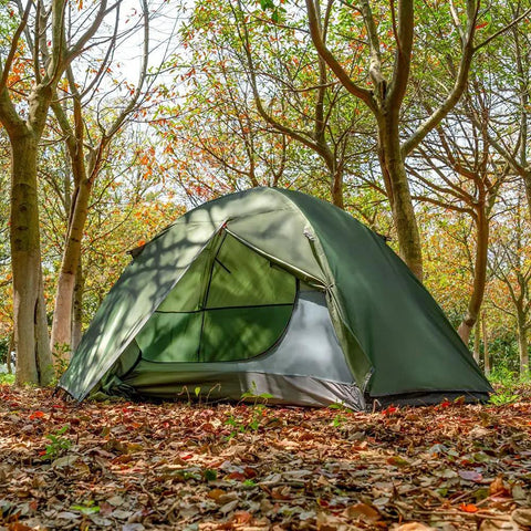 One Person Ultralight Backpacking Tent waterproof double layer in forest with green exterior and aluminum poles for camping