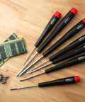 PicoFinish Mini Precision Screwdriver Set, 7-Piece Slotted And Phillips with rotating caps beside electronics parts on wood surface
