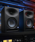 Eris E7 XT 2 Way Active Studio Monitor with EBM Waveguide in home studio setup, showing dual monitors on shelf.
