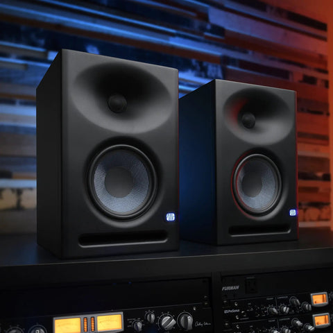 Eris E7 XT 2 Way Active Studio Monitor with EBM Waveguide in home studio setup, showing dual monitors on shelf.