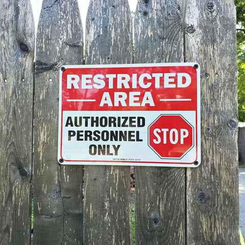 Straight Up Tough Restricted Area Sign Authorized Personnel Only Do Not Enter Safety Plaque on wooden fence, red and white design.