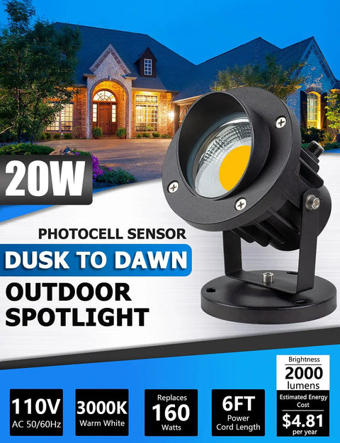 Lit 20W Outdoor COB Landscape Spotlight With Dusk To Dawn Sensor, black housing, warm light, in front of a house at dusk.
