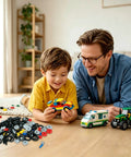 Father and son building with 118 Piece Wheels And Axle Set For Building Blocks with cars and parts on floor.