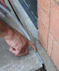 Person using All Purpose Foam Backer Rod For 3/4 Inch Expansion Joints, Gray Caulking to seal concrete gap.