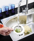 Placing 4.5 Inch Stainless Steel Sink Strainer Basket Pack Of 2 Universal Kitchen Drain Filter Hair Catcher into a kitchen sink.