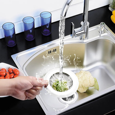Placing 4.5 Inch Stainless Steel Sink Strainer Basket Pack Of 2 Universal Kitchen Drain Filter Hair Catcher into a kitchen sink.
