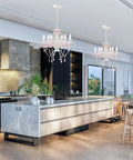 Two white crystal chandeliers with pink droplets and strands enhance kitchen decor with vintage glam lighting and scroll arm frames.
