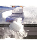 Roof Snow Rake With Seventeen Inch Wide Head And Fifteen And A Half Foot Telescoping Pole For Quick Snow Removal From The Ground No Fuss Snap Together Assembly With Four Fiberglass Handles Ideal Roof Clearing Tool Assembled In The USA blue roof snow rake clearing snow from a pitched roof