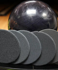 Bowling Ball Sanding Pads 6 Pack All Grits 500 1000 1500 2000 3000 5000 Resurfacing Set displayed in front of bowling ball