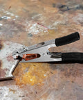 Heavy Duty Copper Welding Ground Clamp With Strong Load Bearing Iron Construction Perfect For Easy Use In Serious Welding Scenarios And Reliable Performance on a metal surface.