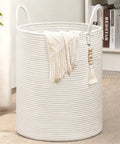 White Laundry Basket With Handles, Tall Woven Hamper For Clothes And Towels, 16x20 inches, with blanket in living room.