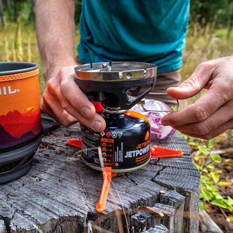 Setting up MiniMo Camping And Backpacking Stove Cooking System With FluxRing Technology on a tree stump for quick boil