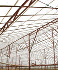 Greenhouse roof framework showing support beams and wires hanging from ceiling, suitable for 10 Pack Nylon Pulley Set applications.