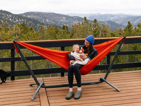 Portable Hammock Stand 15 Lb Lightweight With Quick Setup And Chair Mode Carry Bag And Straps Hang Anywhere From Home To Travel Tailgate Camping Park Or Backyard Not Included Hammock in use on a deck with mountain view.