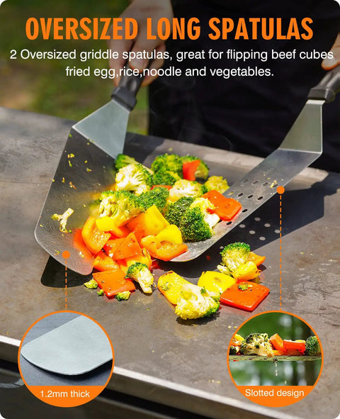 Two oversized stainless steel spatulas flipping vegetables on a grill, part of the Heavy Duty Griddle Gear Kit Eight Piece Spatula Set.