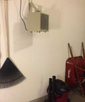 HF5848TC Beefy Garage And Workshop Portable Heater mounted on wall in a garage with fan forced heat, wall bracket visible